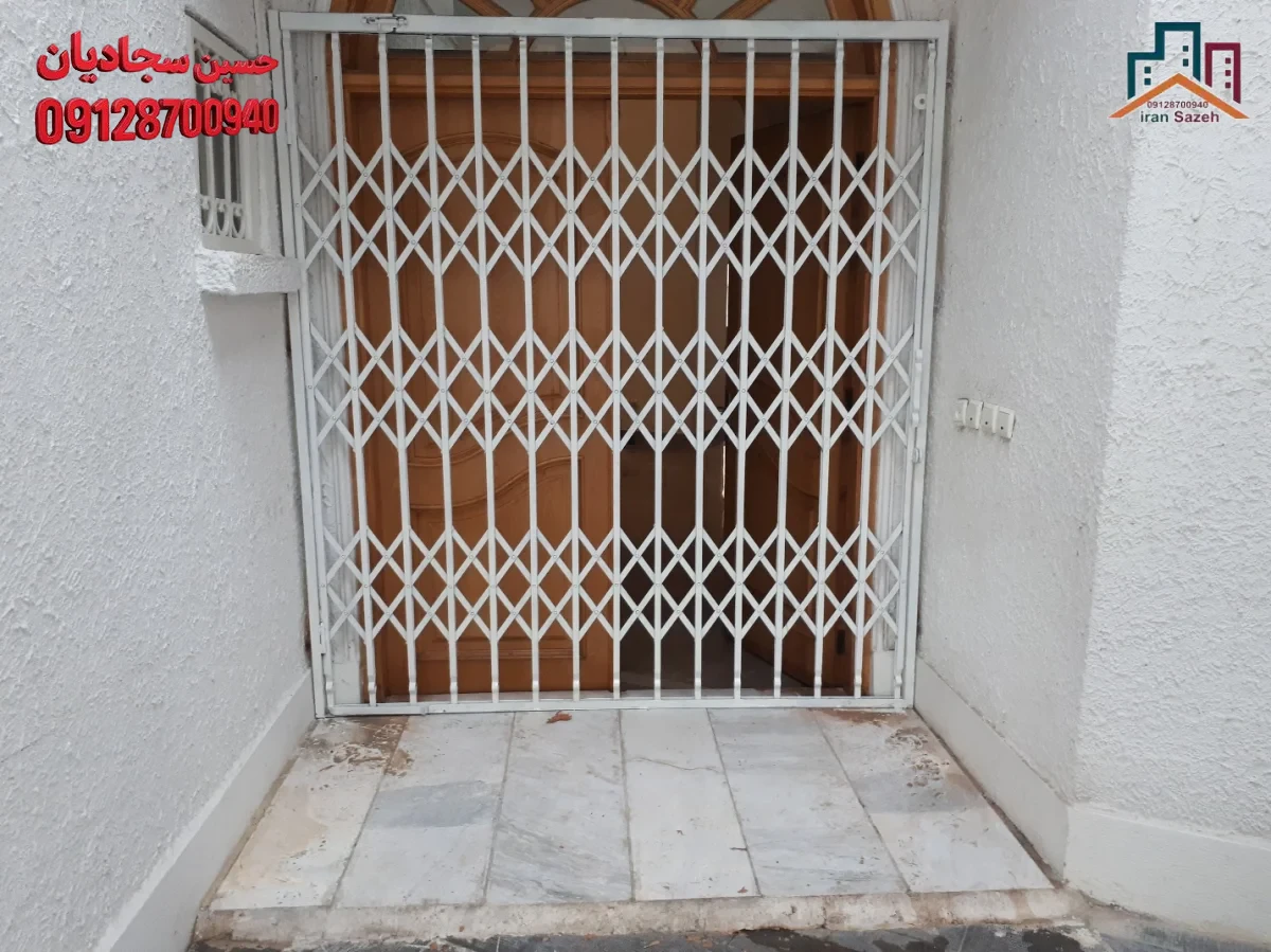 حفاظ آکاردئونی معمولی نصبشده روی درب ورودی همکف با پروفیل سنگین و رنگ کورهای